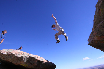 Student jumping over gap in rocks